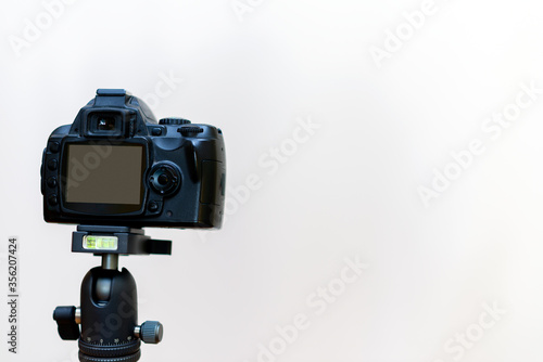 Camera on a tripod.White studio background.Copy space.waiting for a blogger.