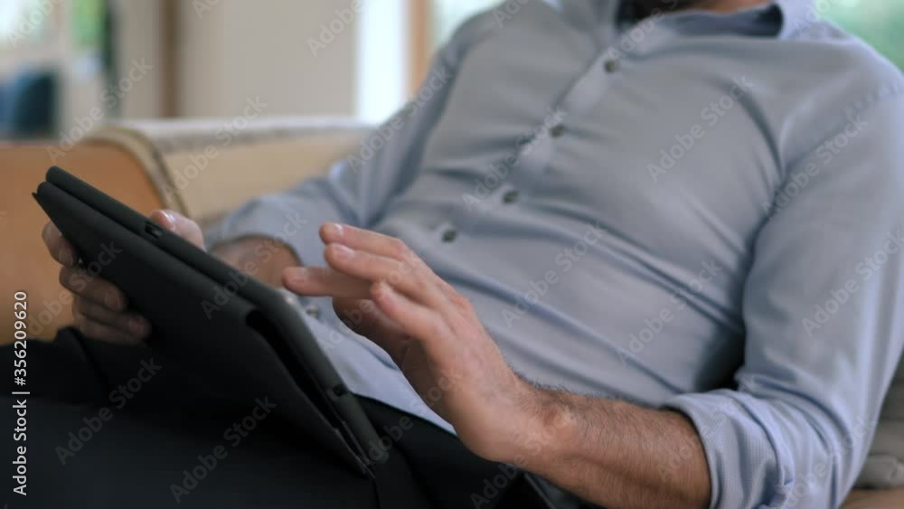 CU Man sitting and using tablet / Lyngby,Denmark CU Man sitting and using tablet / Lyngby,Denmark