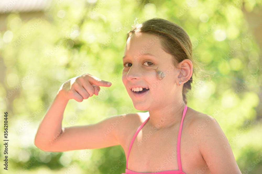 Portrait of a beautiful girl with a snail. A snail on the face of a child. A young girl is playing with a snail. Summer walks in the park.
Portrait of a beautiful girl with a snail. A snail on the face of a child. A young girl is playing with a snail. Summer walks in the park.