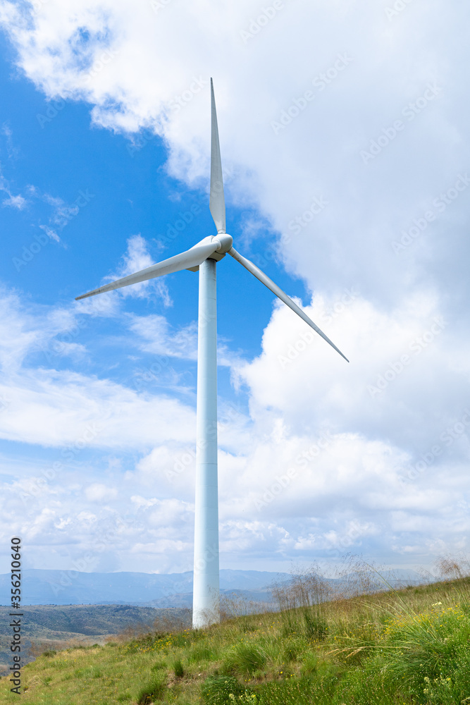 windmills used to generate energy, in the foreground with sky and sunny blue day..