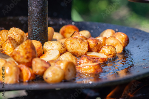 Grilled potato on frying pan on open fire