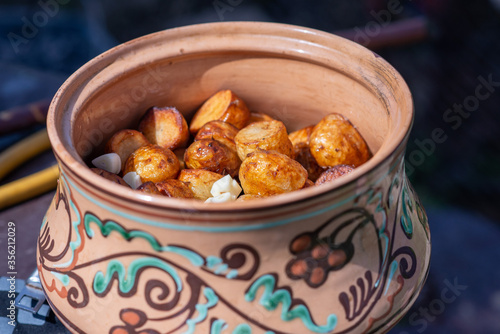 Grilled potato on frying pan in clay pot