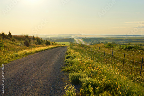 A country road in the Flint Hills of Kansas on a foggy summer morning.