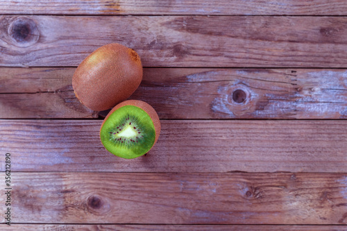 On a wooden background lies a juicy kiwi