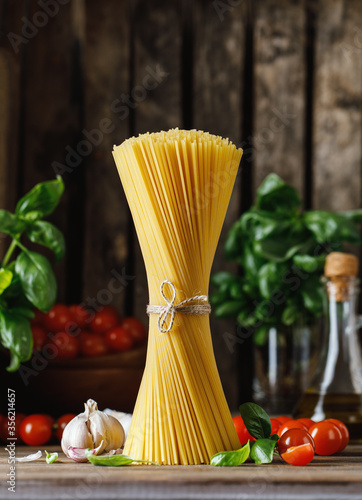 Raw spaghetti on rustic background. Ingredients for pasta