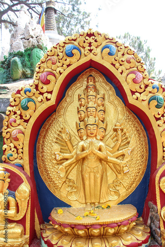 View of carved golden statue of eleven-headed Avalokite  vara bodhisattva who embodies the compassion of all Buddhas. Monument is located in Buddha Garden in Kathmandu city  Nepal.