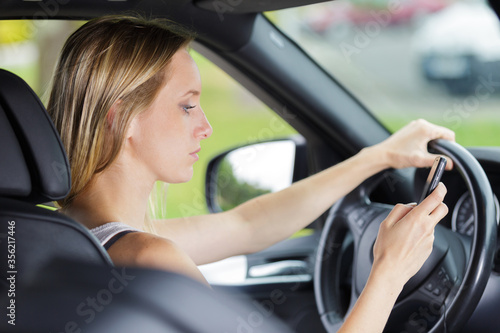 woman driver using smart phone in car during driving © auremar