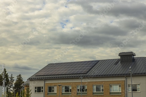 View of building roof equipped with solar panels. Modern technology concept. 