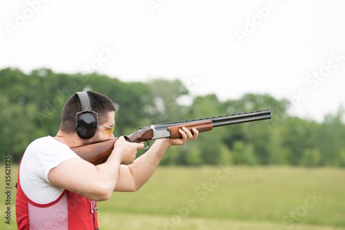 Man shooting skeet with a shotgun. Skeet shooting, trap shooting.
