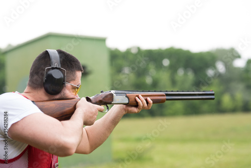 Man shooting skeet with a shotgun. Skeet shooting, trap shooting.