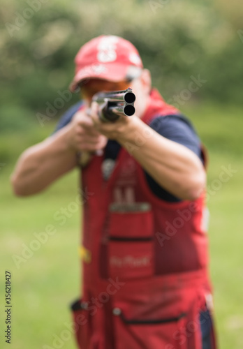 Man shooting skeet with a shotgun. Skeet shooting, trap shooting.