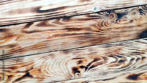 Wooden background. Texture of burned wood. Beautiful drawing on the surface of the boards. photo