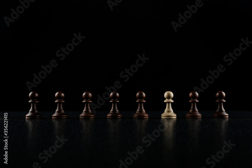 chess concept of individuality. black pawns on black background