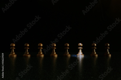 chess concept of individuality. black pawns on black background