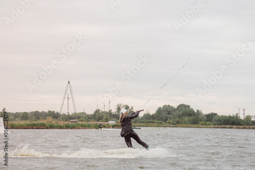 Athletic girl swims on a wakeboard. A woman on the lake swims on a wakeboard. Sports photo shoot.