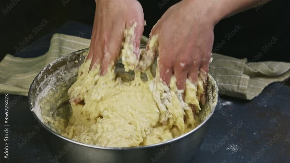 closeup woman hands quickly knead soft yeast dough in big deep metal bowl closeup woman hands quickly knead soft yeast dough in big deep metal bowl