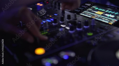 Wallpaper Mural DJ sound control console for mixing dance music and laptop in disco club. Hands touching buttons sliders, playing electronic music on mixing deck, color illumination in nightclub dance party. Close up Torontodigital.ca