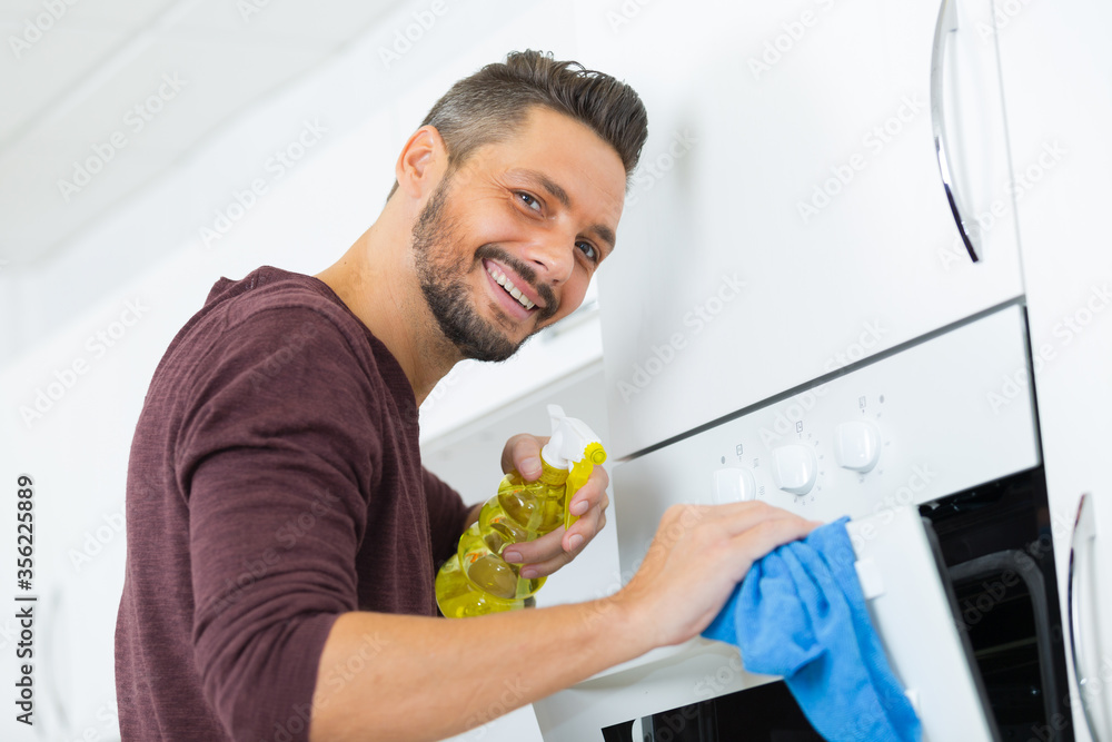 man cleaning oven carefully man cleaning oven carefully