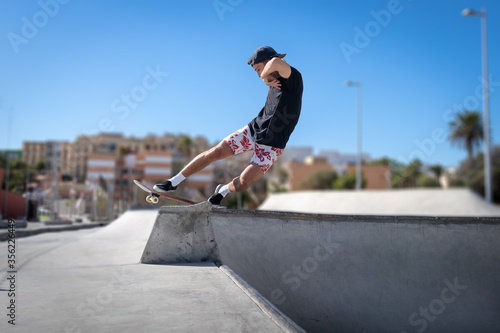 Joven skater hace un truco llamado "rock to fakie" en el borde de una piscina de skate. Movimiento 3