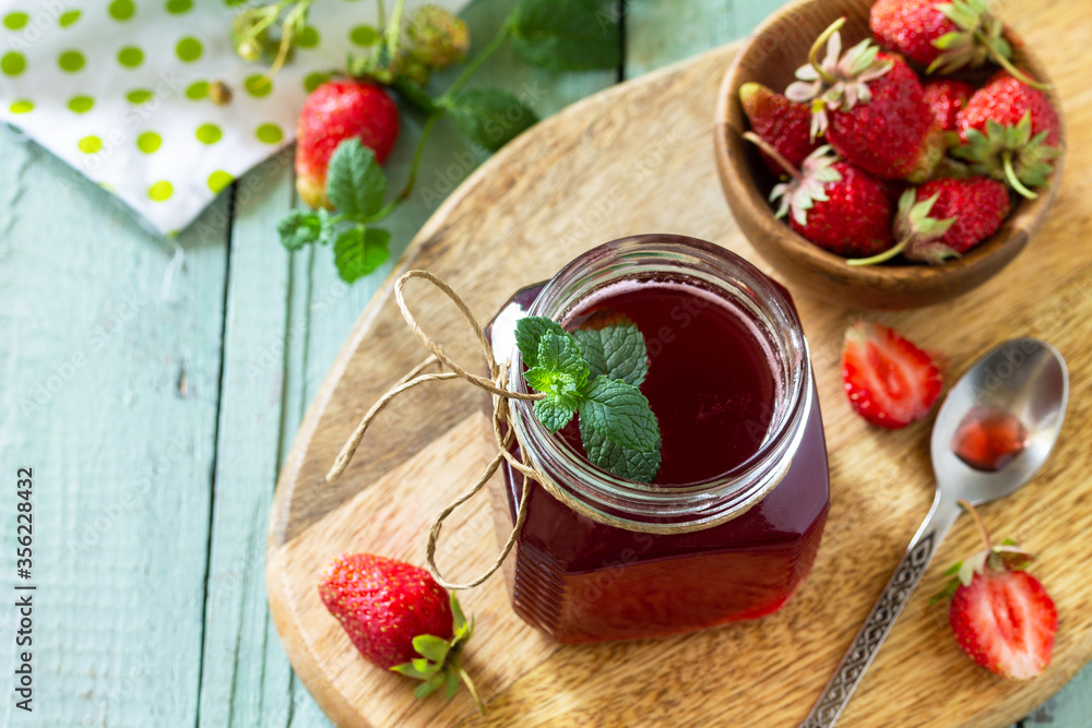 Homemade preservation concept. Strawberry berry syrup and fresh strawberry berries on a wooden table. Copy space. Homemade preservation concept. Strawberry berry syrup and fresh strawberry berries on a wooden table. Copy space.