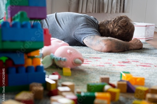 Tired dad taking a nap in a messy home. Parenthood.