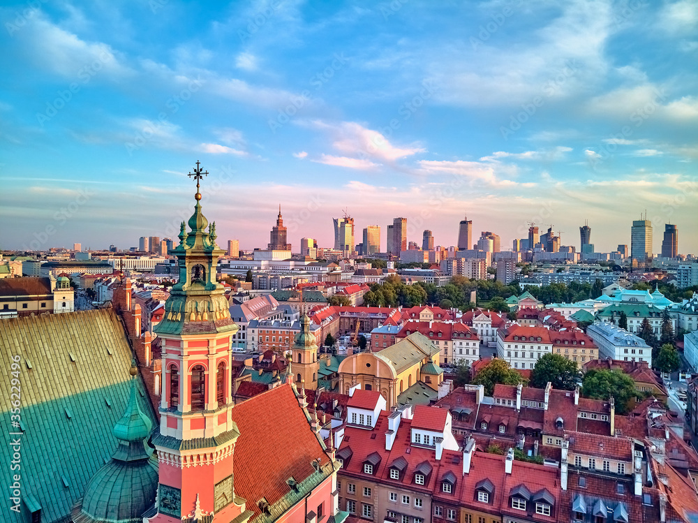 Fototapeta premium Beautiful panoramic aerial drone view on Warsaw Old town (POL: Stare Miasto) with modern skyscrapers on the horizon, Royal Castle, square and the Column of Sigismund III Vasa at sunset, Poland