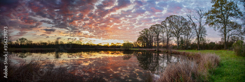 Foto Panoramic View of Clouds and Trees Reflected in A Pond in St