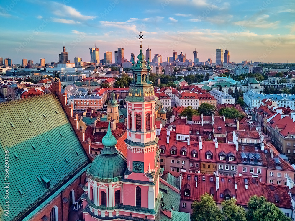 Fototapeta premium Beautiful panoramic aerial drone view on Warsaw Old town (POL: Stare Miasto) with modern skyscrapers on the horizon, Royal Castle, square and the Column of Sigismund III Vasa at sunset, Poland