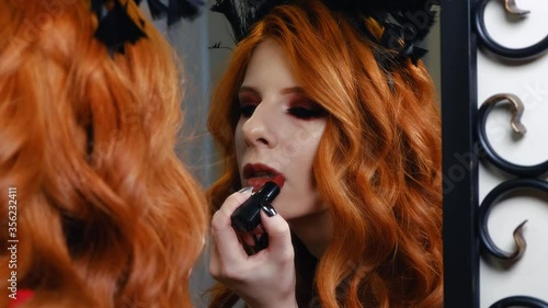 Gothic girl putting on lipstick in slow-mo shooting