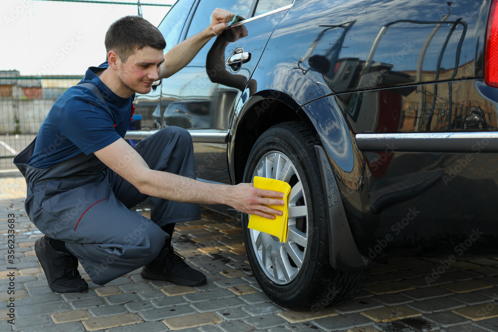 A man rubs a car. Car wash. Clear car concept A man rubs a car. Car wash. Clear car concept