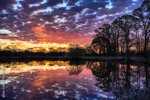 Dramatic Colorful Clouds Reflected in Small Pond at Sunrise in Sunset Louisiana in Early March