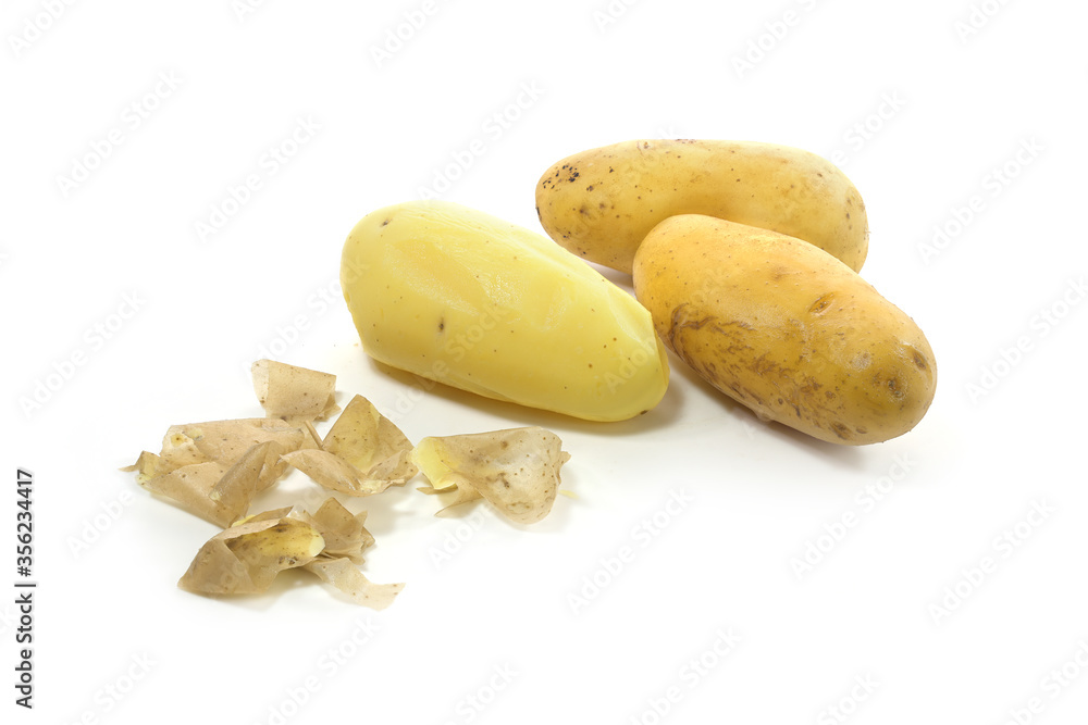 Three young potatoes boiled in their skins, one of them peeled, isolated on a white background, copy space Three young potatoes boiled in their skins, one of them peeled, isolated on a white background, copy space