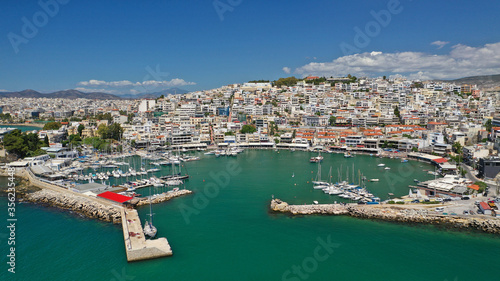 Aerial drone bird's eye view panoramic photo of iconic round shaped picturesque port of Mikrolimano with sail boats and yachts docked and beautiful clouds, Piraeus port, Attica, Greece © aerial-drone