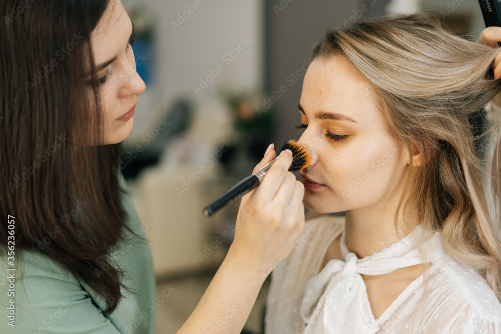 Close-up of beautiful woman model preparing for filming in lighting dressing room. Concept of backstage work. Close-up of beautiful woman model preparing for filming in lighting dressing room. Concept of backstage work.