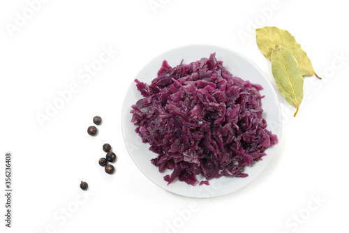 Portion of cooked red cabbage on a plate  juniper berries and bay leaves  isolated on a white background  copy space  high angle view from above