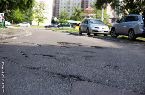 Broken asphalt and cracks on the road surface © Hennadii
