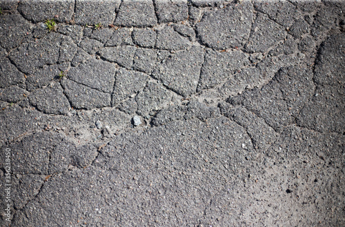 Broken asphalt and cracks on the road surface