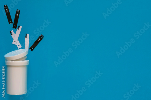 Diabetes. Monitoring blood glucose levels in diabetics. Packaging test strips for measuring blood sugar. Test Strips for glucose meter. A healthy lifestyle diabetic. Macro photo. Blue background