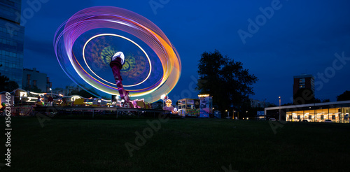 Carousel spinning at high speed in small amusement park at night