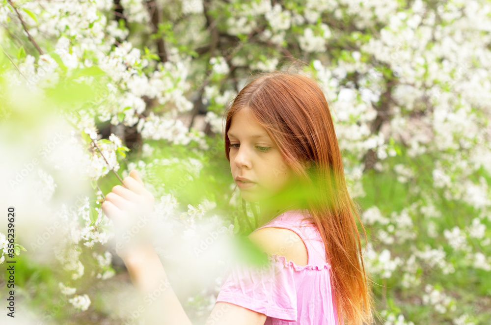 a girl in protective face mask stands near blossoming cherry tree during quarantine due to the coronavirus pandemic a girl in protective face mask stands near blossoming cherry tree during quarantine due to the coronavirus pandemic
