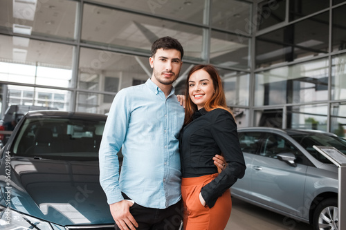 Young couple at a car dealership near their new auto