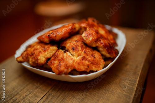 Homemade chicken cutlets. The plate is full of delicious chicken meatballs prepared for food. Fried chicken cutlets. Grilled chicken breast on a white dish on an old wooden background.