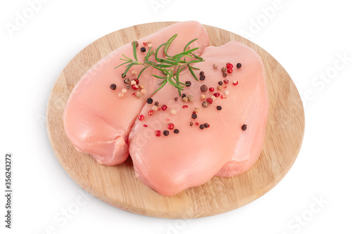 Fresh chicken fillet with rosemary on wooden board isolated on white background with clipping path and full depth of field.