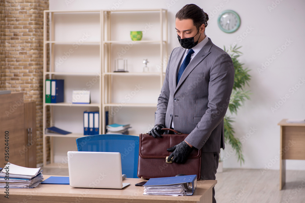 Young male employee in the office during pandemic disease Young male employee in the office during pandemic disease