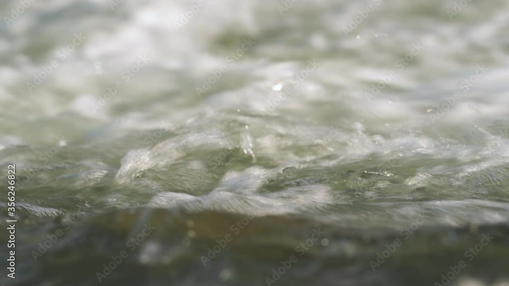 Closeup detail, water flowing in river on sunny day Closeup detail, water flowing in river on sunny day