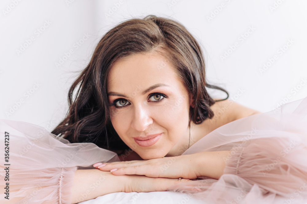 Cheerful and happy bride in a beautiful pink light wedding dress. Gorgeous makeup and hairstyle Cheerful and happy bride in a beautiful pink light wedding dress. Gorgeous makeup and hairstyle