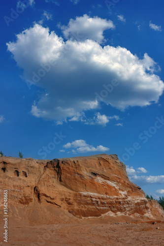 Sand dunes against the blue sky and white clouds.