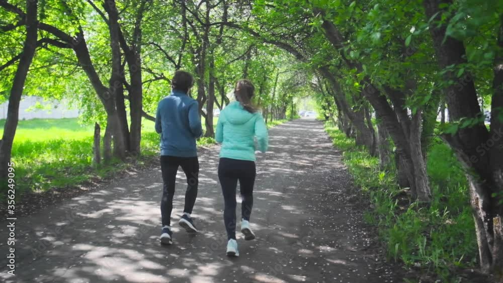 Sportive young people running. Couple run in the park during the day. Sportive young people running. Couple run in the park during the day.