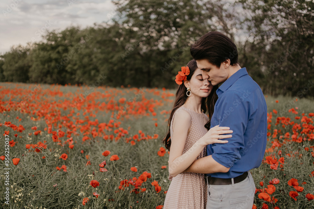 Happy couple in poppy fieldin summer time Happy couple in poppy fieldin summer time