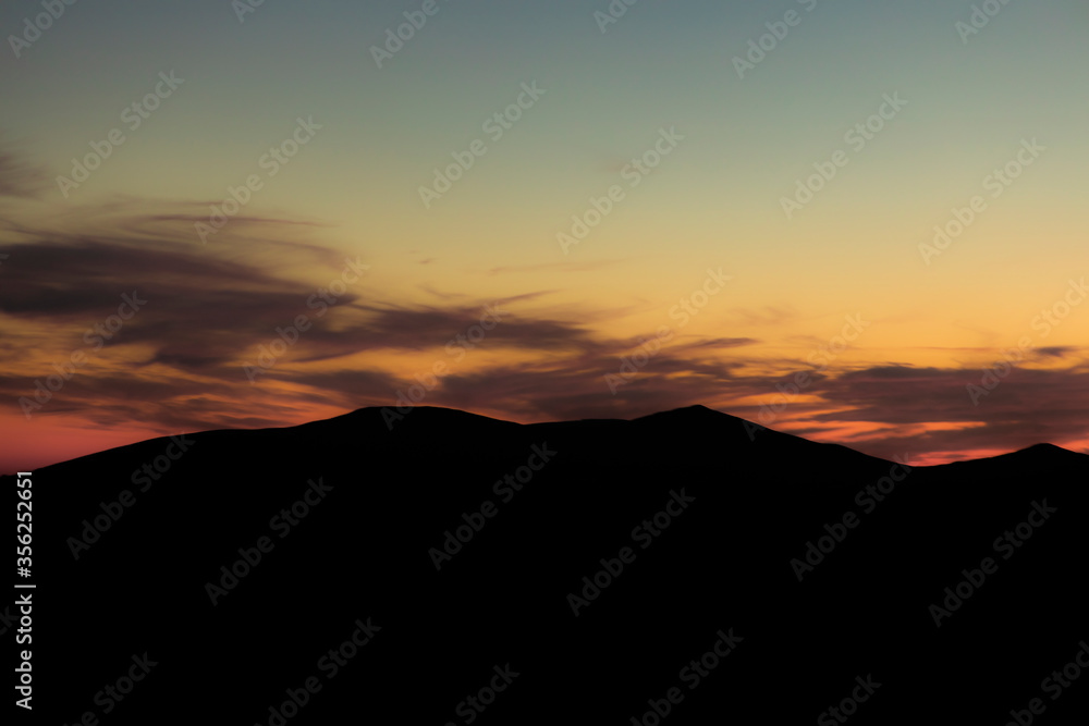 mountain ridge silhouette landscape background of moody dramatic weather time with soft color orange sunset lighting mountain ridge silhouette landscape background of moody dramatic weather time with soft color orange sunset lighting